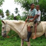 Boys riding a horse in the Rural areas, Dominican Republic